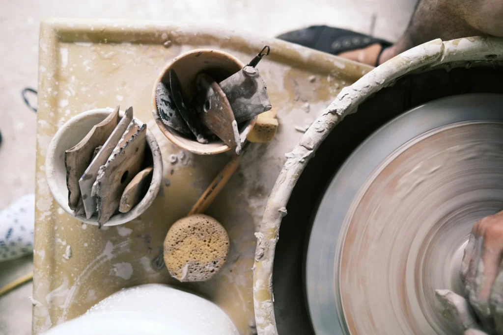 Potter's wheel with clay-covered tools in a ceramics studio